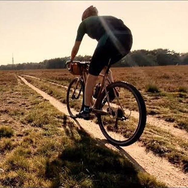 Gravelbiker op een zandpad over de heide bij Buitengoed de Bollen